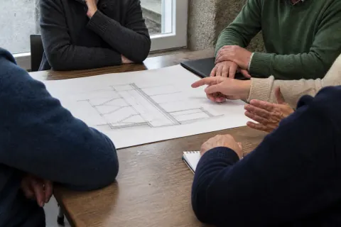 Reunión de comunidad ante un esquema de portal y hueco de ascensor